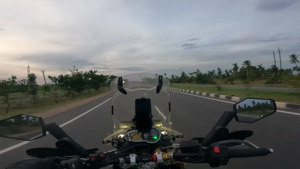 Raw camera footage: a flat highway seen from the handlebars
